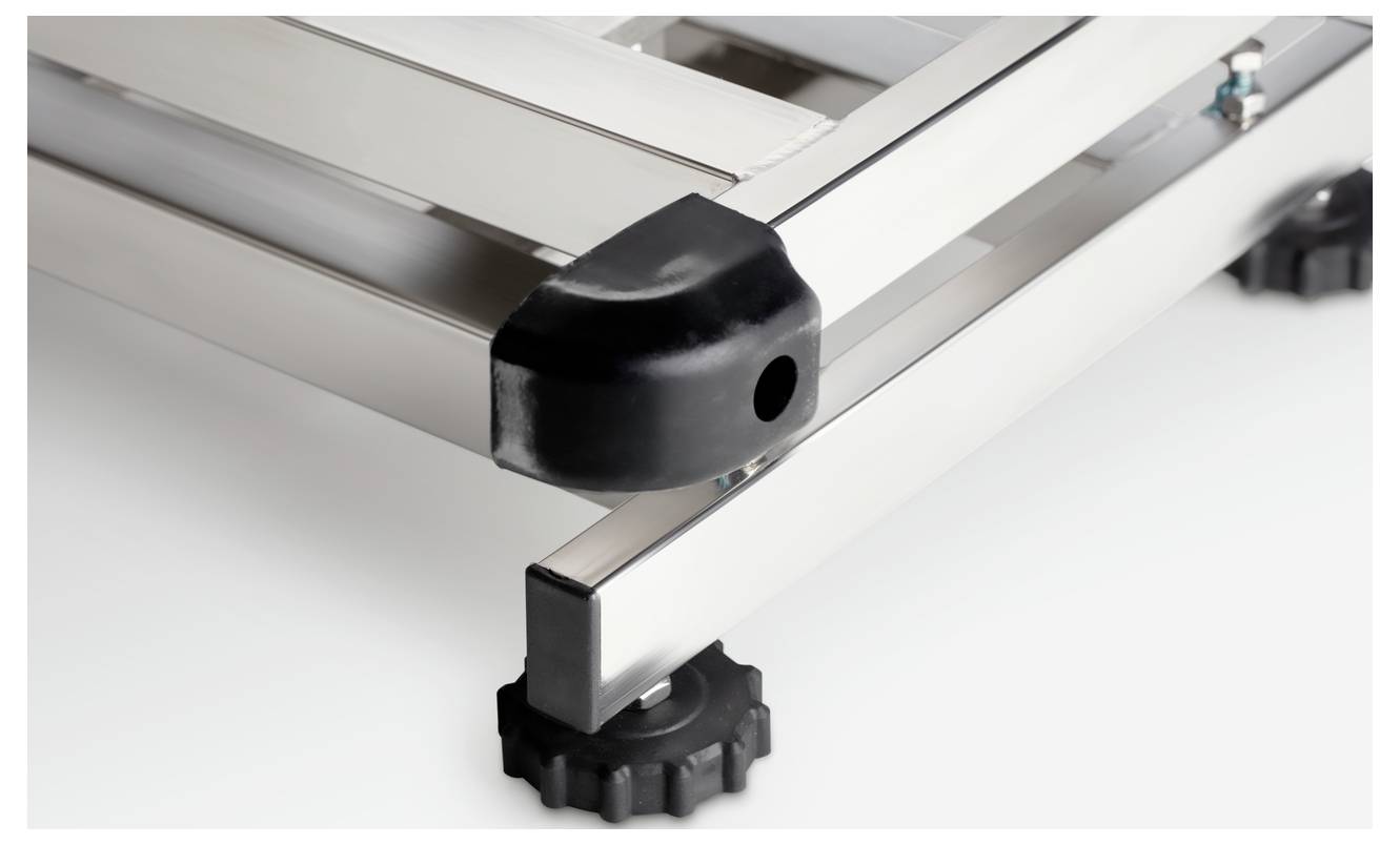 Gros plan sur un cadre rectangulaire métallique avec des embouts d'angle en plastique noir et des roues dentées aux pieds, offrant une stabilité renforcée.