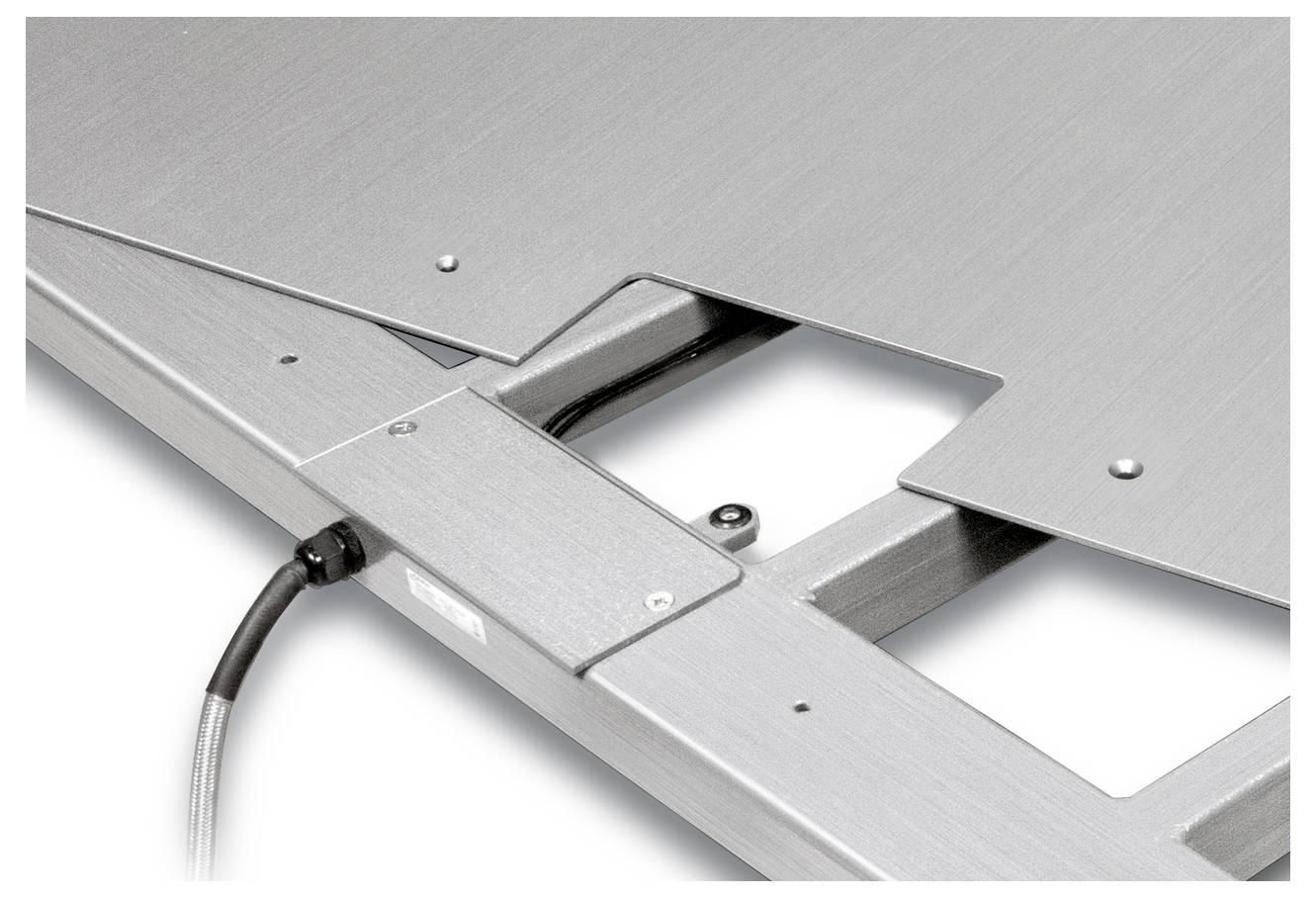 Gros plan d'un dispositif métallique avec connexion par câble. Le design présente des bords usinés avec précision et une découpe au centre du cadre.