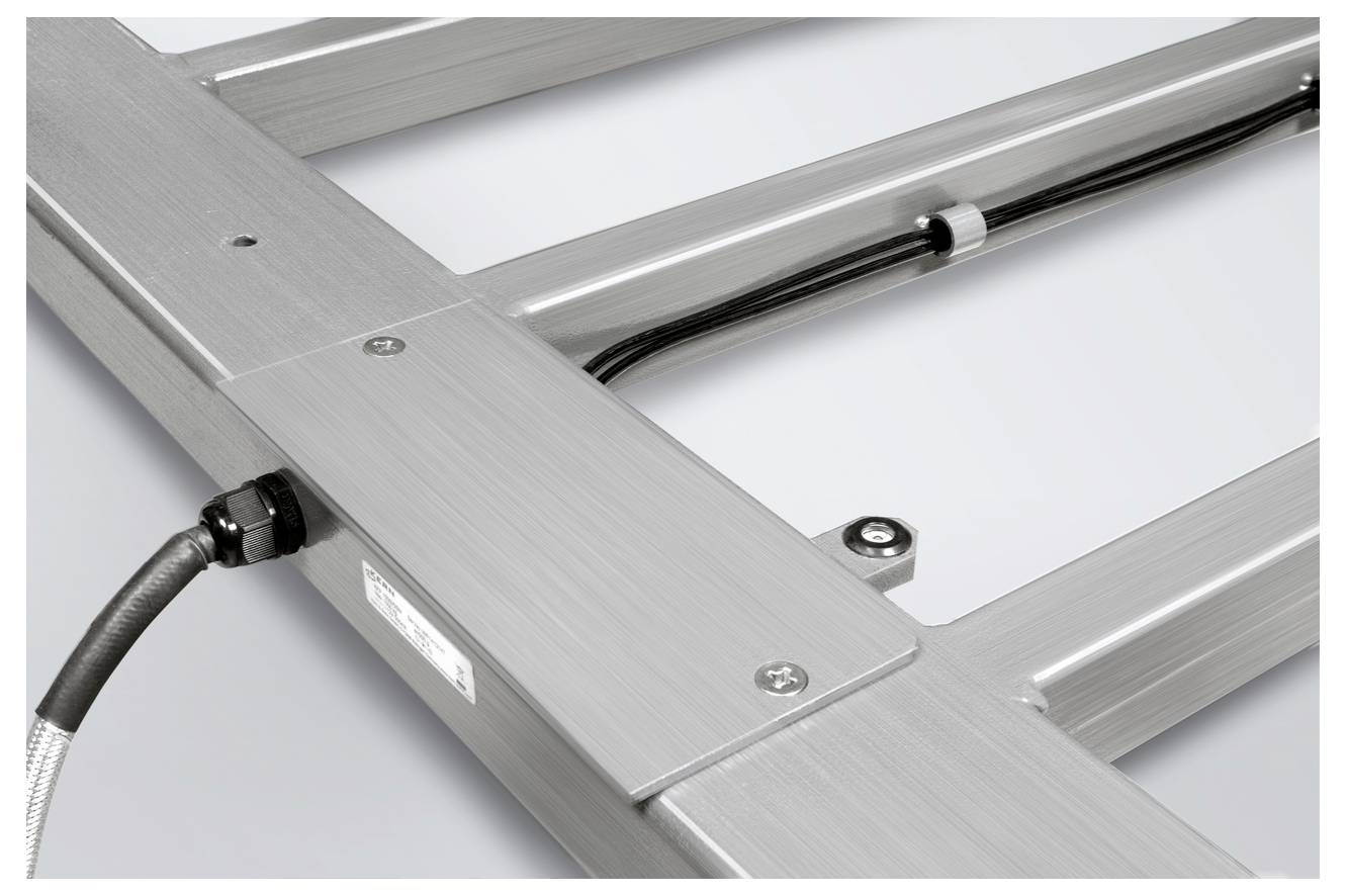 Gros plan d'un cadre métallique avec des connexions de câbles. La surface est argentée et lisse. Composant technique d'un appareil.