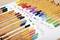 Des crayons de couleur sont disposés par groupes sur une table. À côté se trouvent des dessins de molécules colorés, correspondant aux couleurs des crayons.
