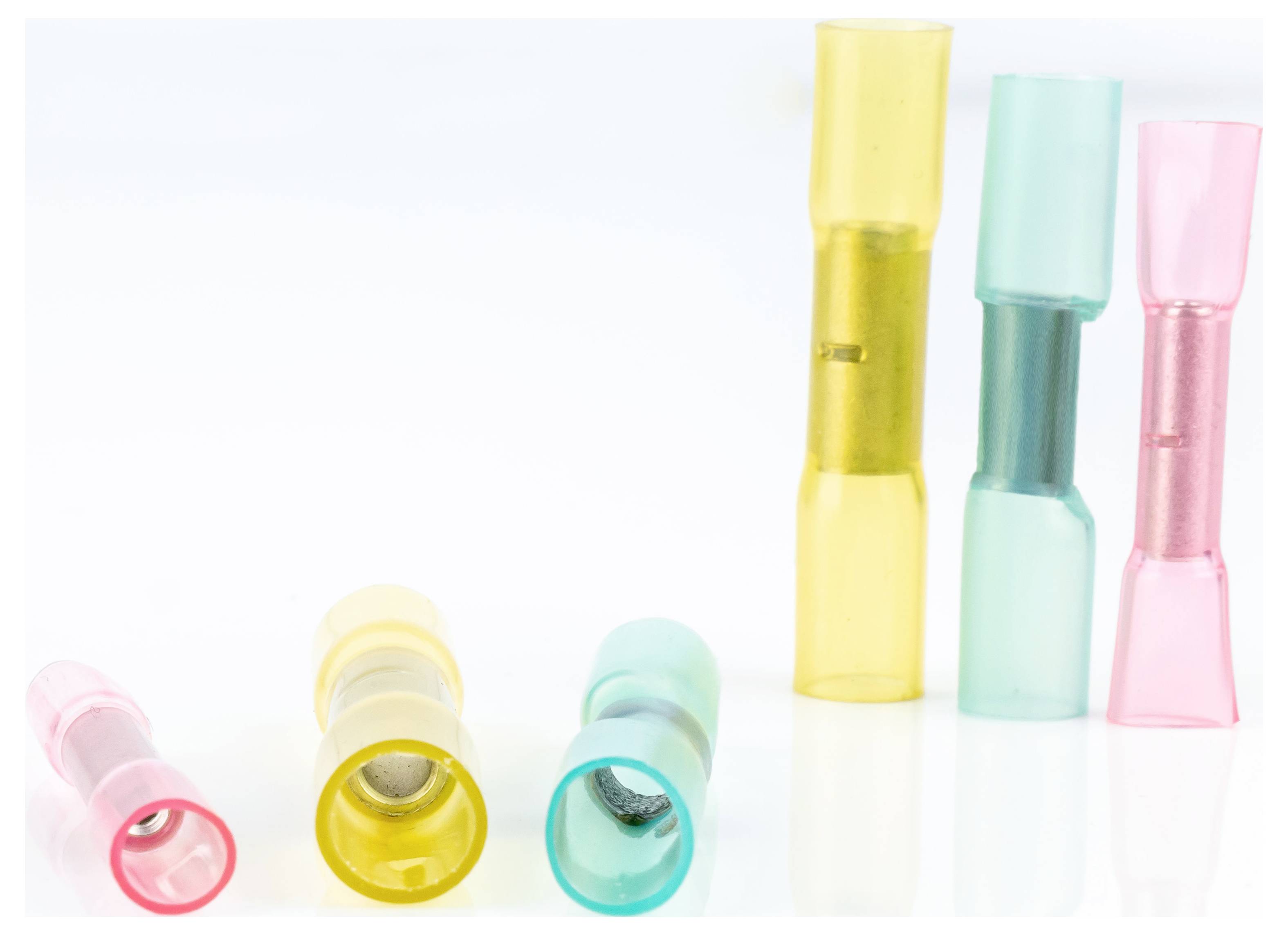 Des connecteurs électriques multicolores de différentes tailles sont disposés et empilés sur un fond blanc.