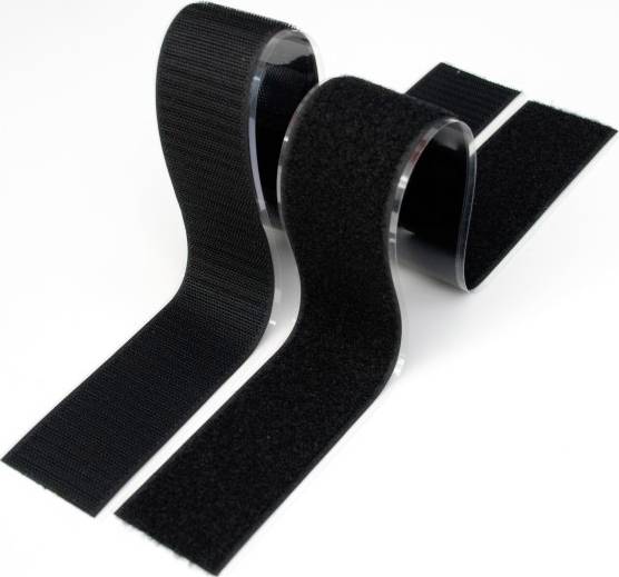 Ensemble de bande auto-agrippante noire sur fond blanc, composé de deux rouleaux. Un rouleau montre le côté crochets et l'autre le côté velours.