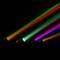 Des rayons lumineux colorés s'étendent de gauche à droite dans une pièce sombre, créant un effet arc-en-ciel.