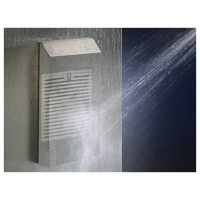 Grille de ventilation en métal à lamelles aspergée par un jet d'eau puissant. Un mur à gauche, de l'eau giclante à droite.
