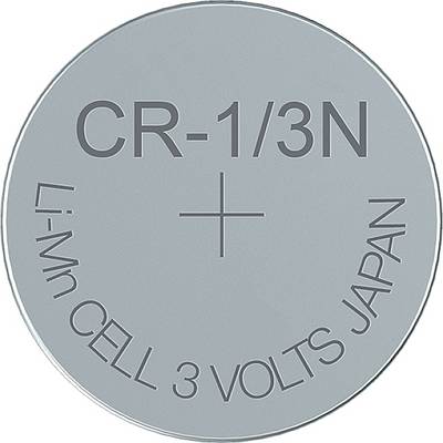 Une pile bouton argentée de type CR-1/3N portant l'inscription « Li-Mn CELL 3 VOLTS JAPAN ».