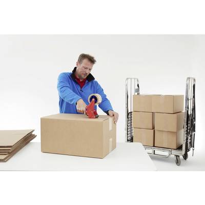 Un homme en veste bleue scelle un grand carton avec du ruban adhésif sur une table. À côté, des cartons empilés sont disposés sur un chariot roulant.