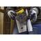 Une personne portant des gants de travail tient une scie à lame métallique, prête à être utilisée. Des briques et du bois sont visibles en arrière-plan.