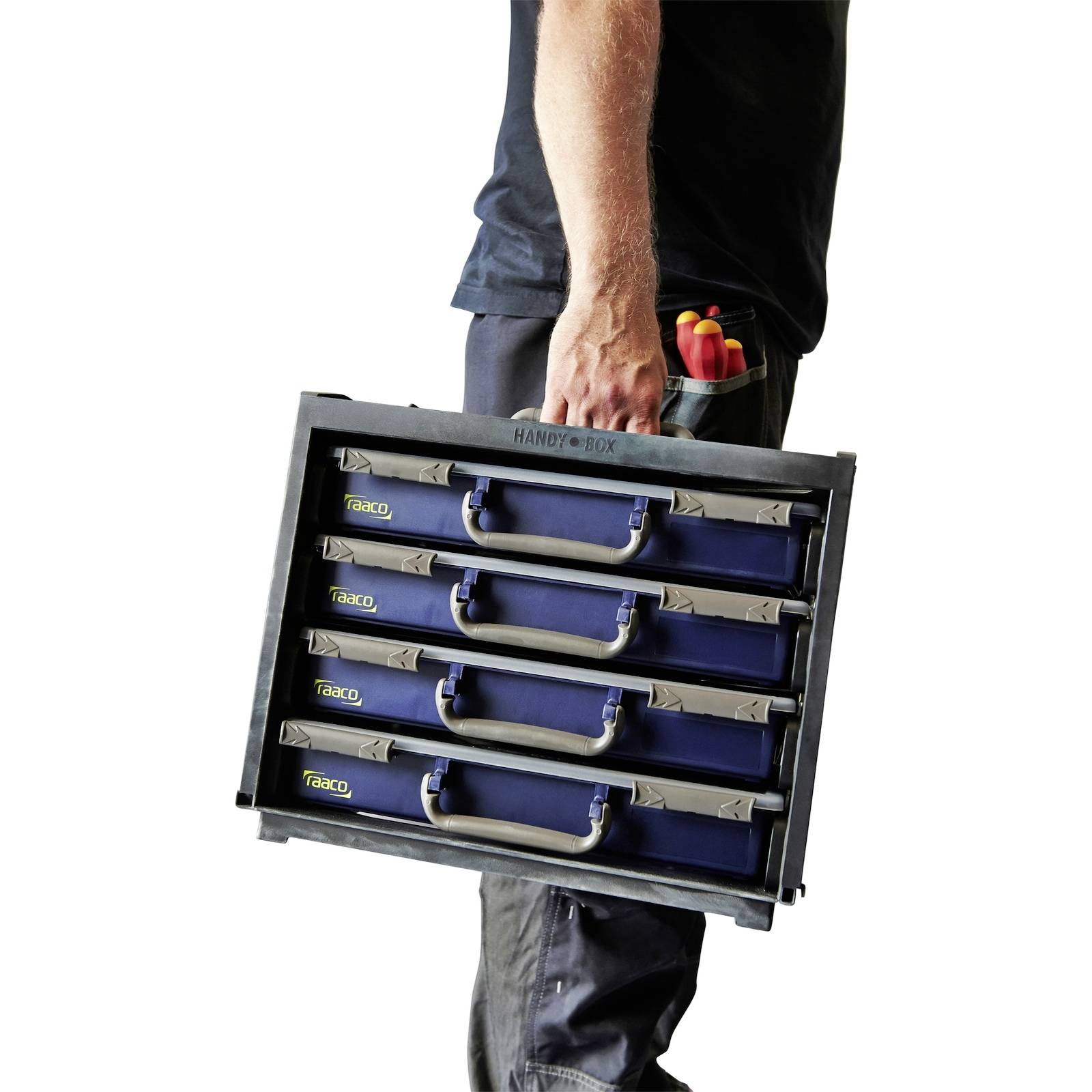Une personne transportant une boîte de rangement pour outils à quatre tiroirs, remplie de divers outils.