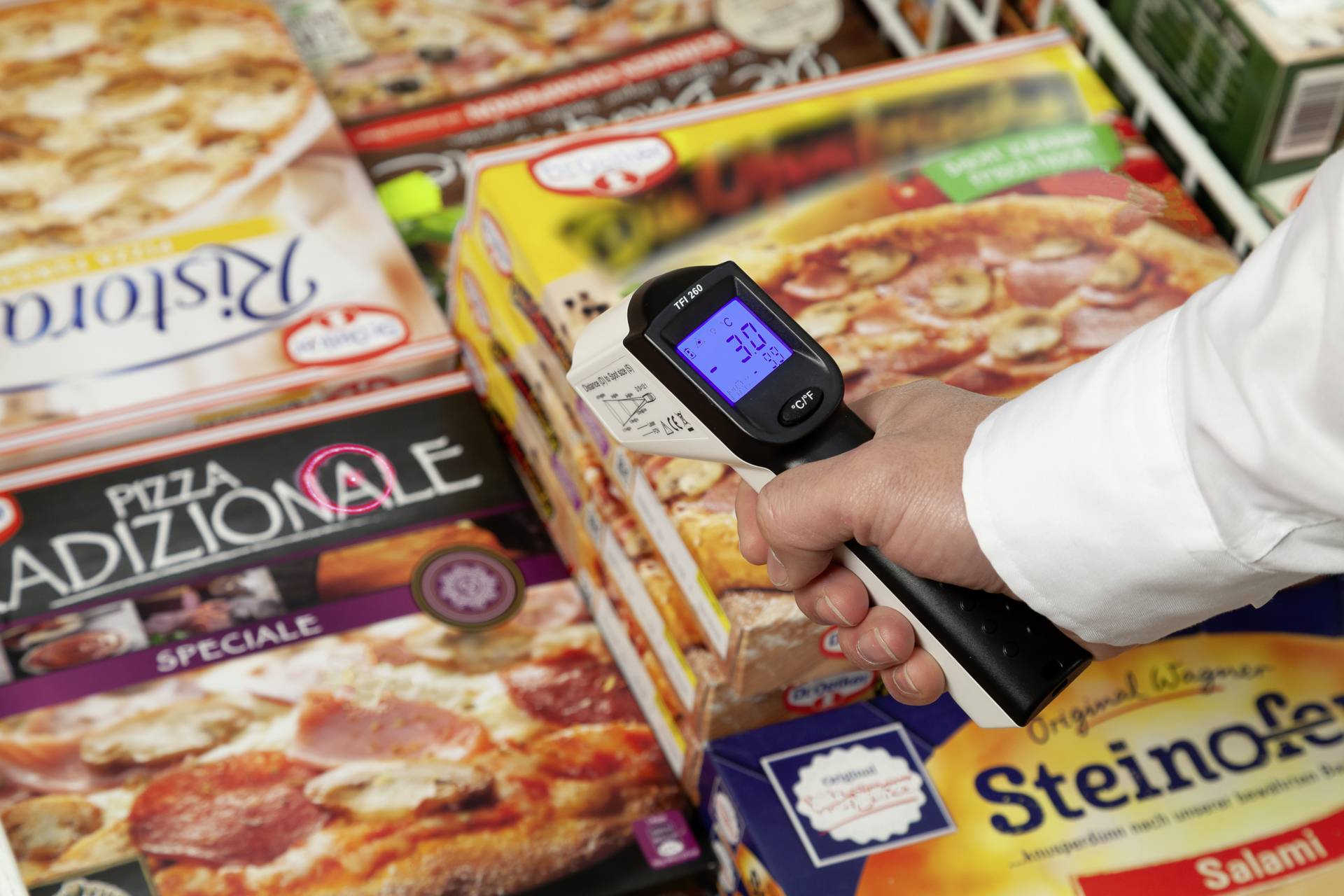 Un thermomètre manuel indique 3,9 degrés Celsius lors de la mesure de la température de pizzas surgelées dans un supermarché.