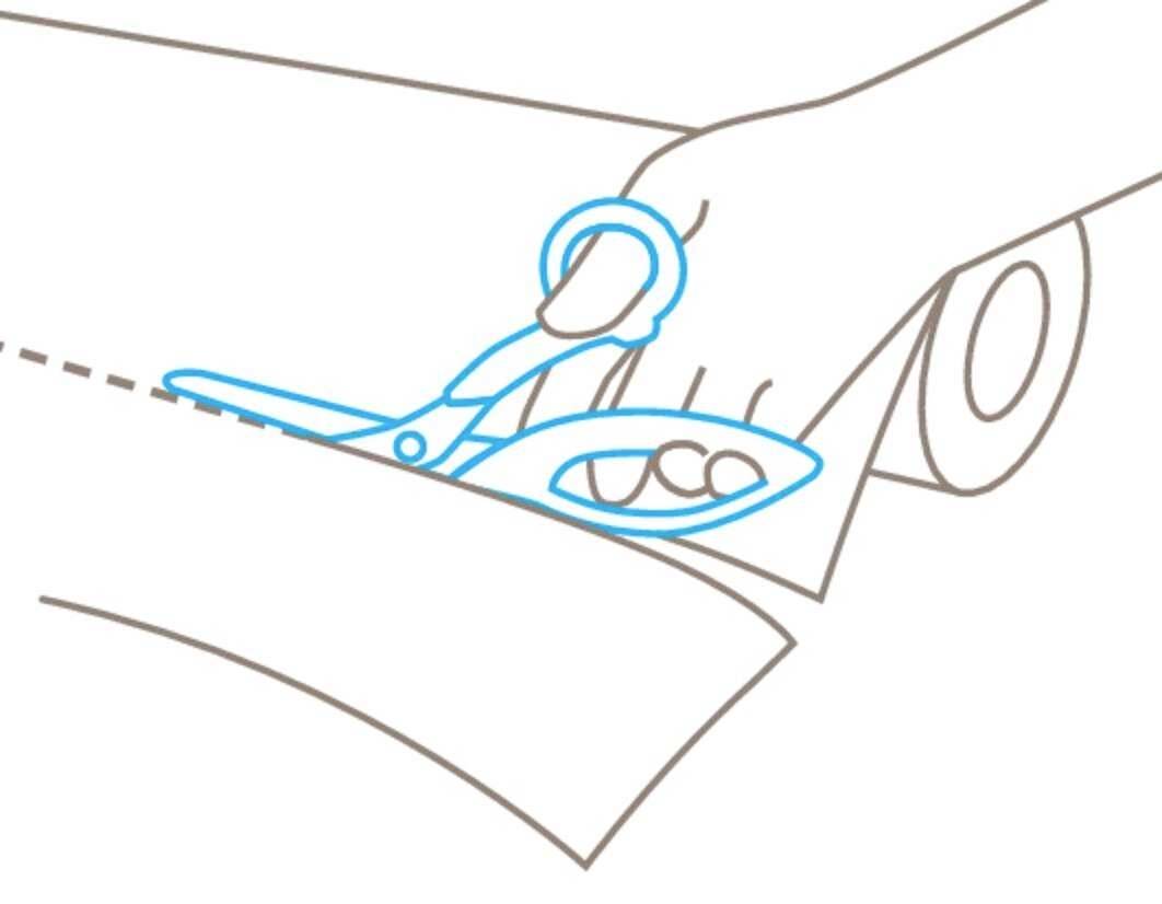 Une main découpe du papier avec des ciseaux. Les ciseaux sont bordés de bleu.