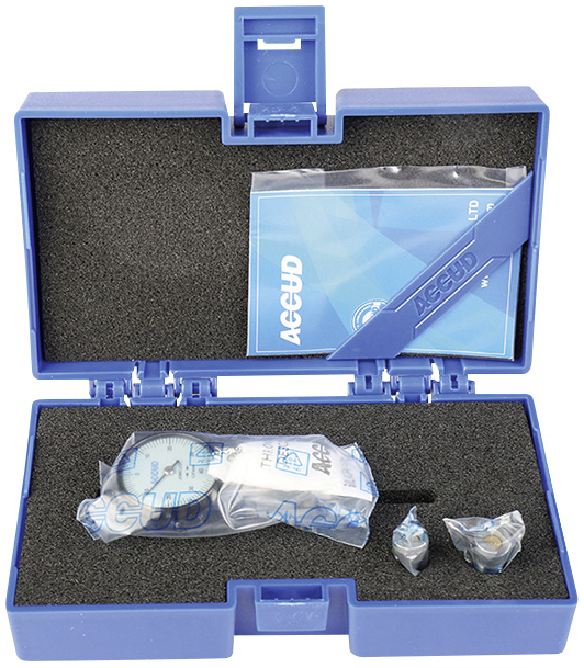 Étui en plastique bleu contenant des composants d'appareil de mesure dans une garniture en mousse. Un cadran, des accessoires et un manuel sont visibles.