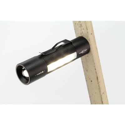 Une lampe de poche noire avec une lumière brillante, fixée à un morceau de bois incliné. Elle dispose d'une surface antidérapante.