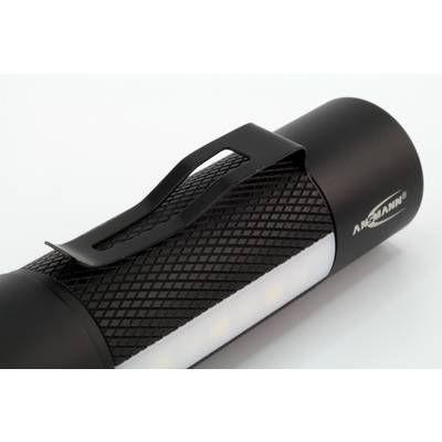 Lampe de poche noire avec clip, posée sur une surface blanche.