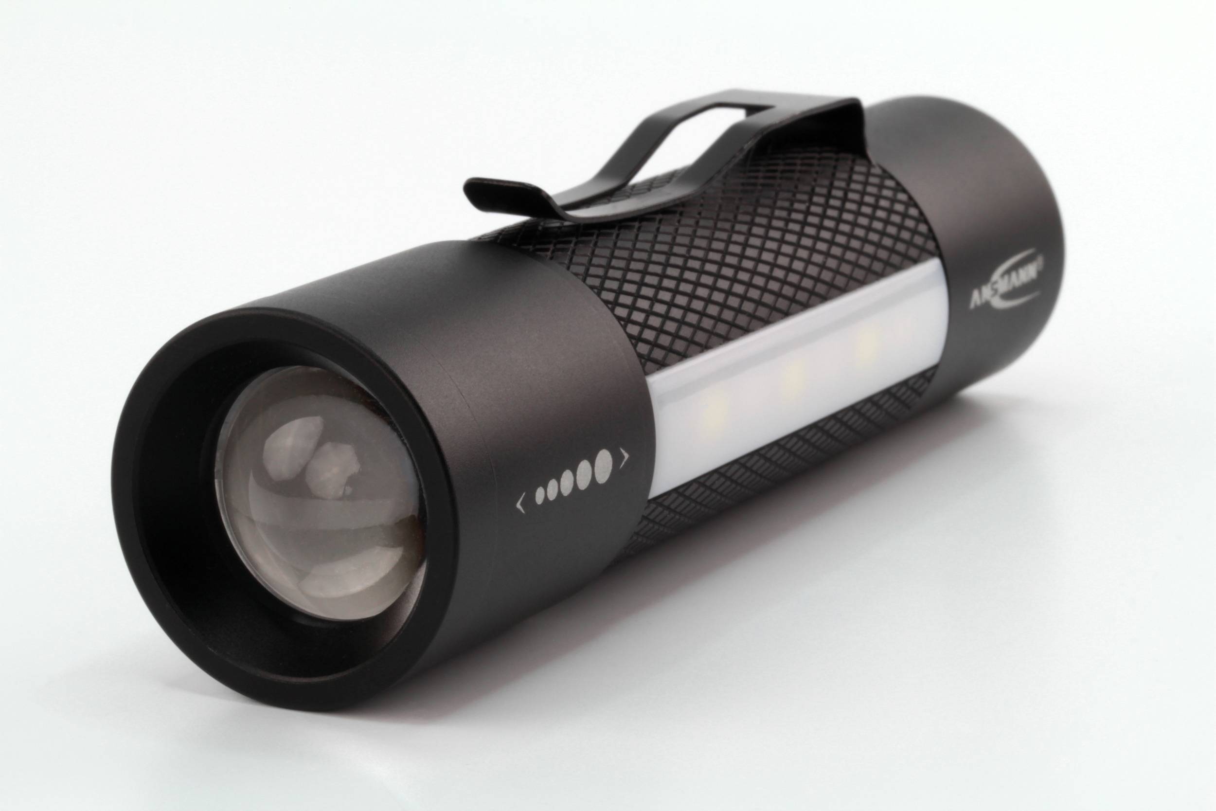 Une lampe de poche noire avec des bandes lumineuses LED et un support est posée sur une surface blanche.