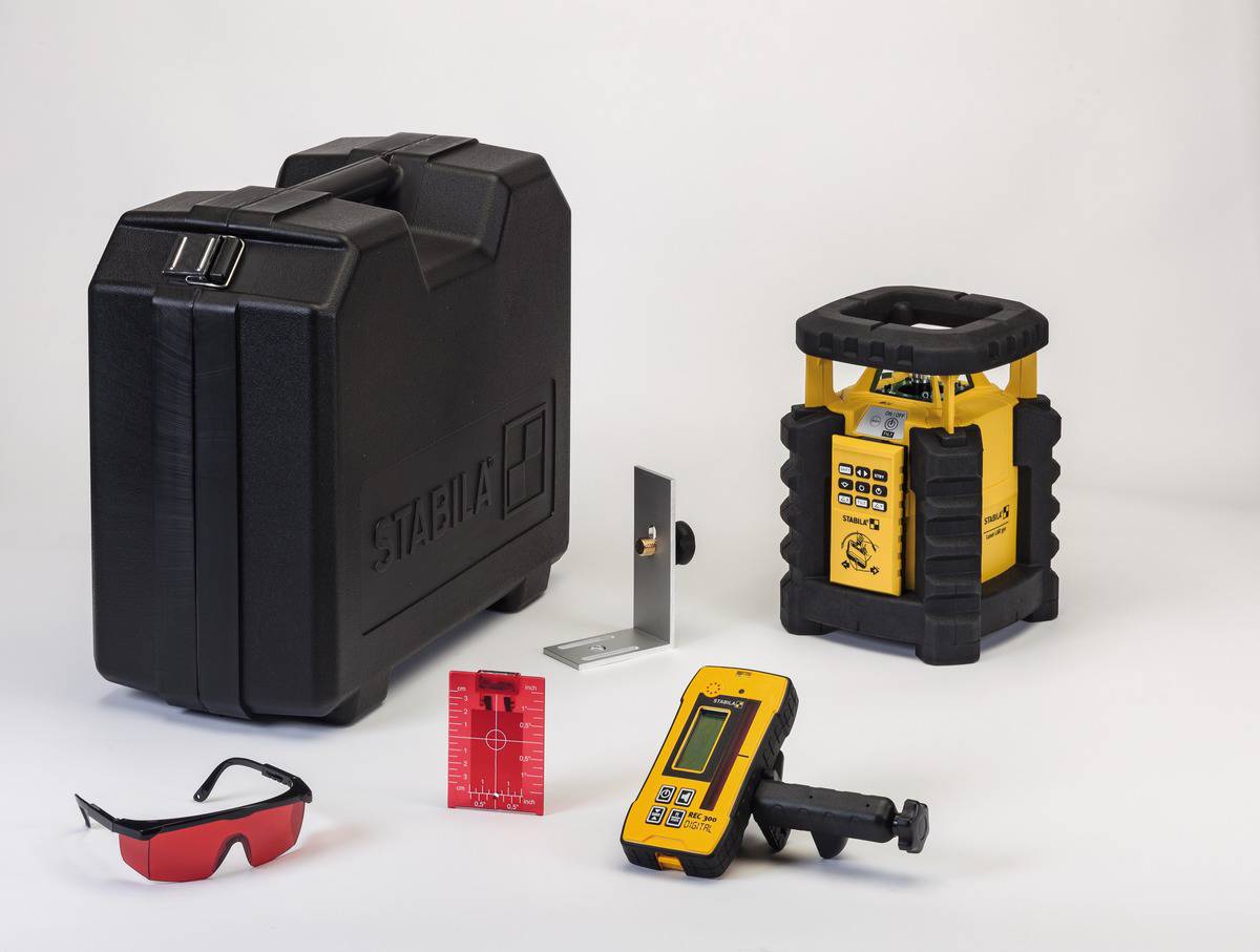 Ensemble Baulaser : Mallette de transport noire, laser rotatif, récepteur, lunettes spéciales rouges et autres accessoires sur fond blanc.