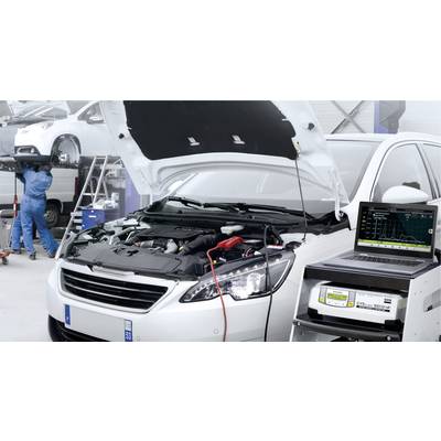 Une voiture avec le capot ouvert est stationnée dans un atelier. Un ordinateur portable affiche des données de diagnostic moteur. En arrière-plan, un mécanicien répare un autre véhicule.