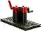 Jouet mécanique rouge et noir sur une base noire avec des pièces mobiles et des leviers, qui stimule la créativité technique.