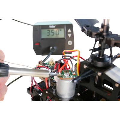 Fer à souder sur un circuit dans un montage technique, tandis qu'un thermomètre indique 350°C ; accent mis sur la précision et le contrôle de la température.