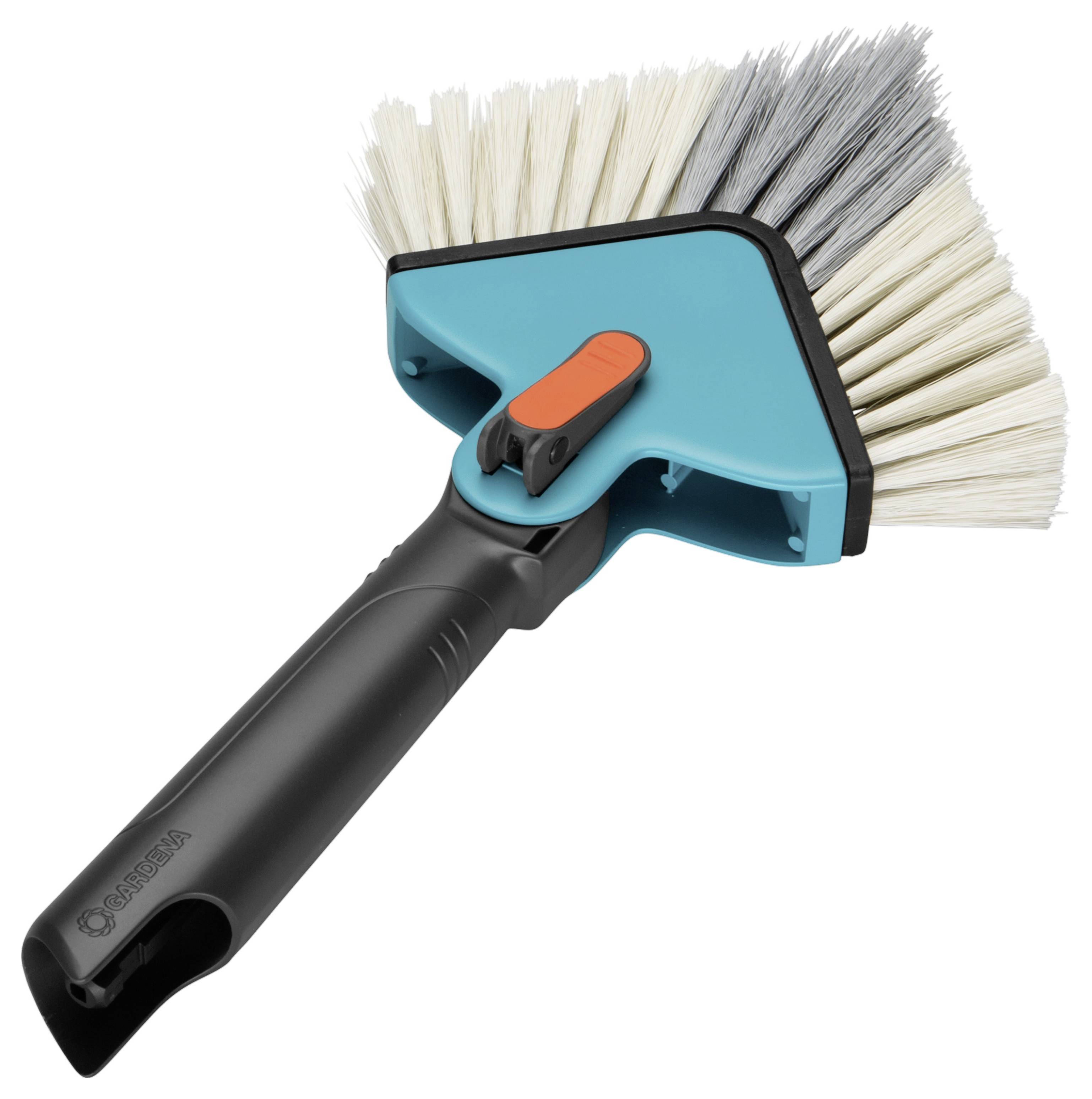Brosse de nettoyage triangulaire avec manche noir et poils blanc et noir, adaptée aux coins difficiles d'accès.
