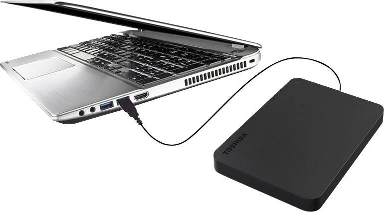 Un ordinateur portable à moitié ouvert, connecté à un disque dur externe via un câble USB, symbolise la sauvegarde de données ou l'extension de stockage.