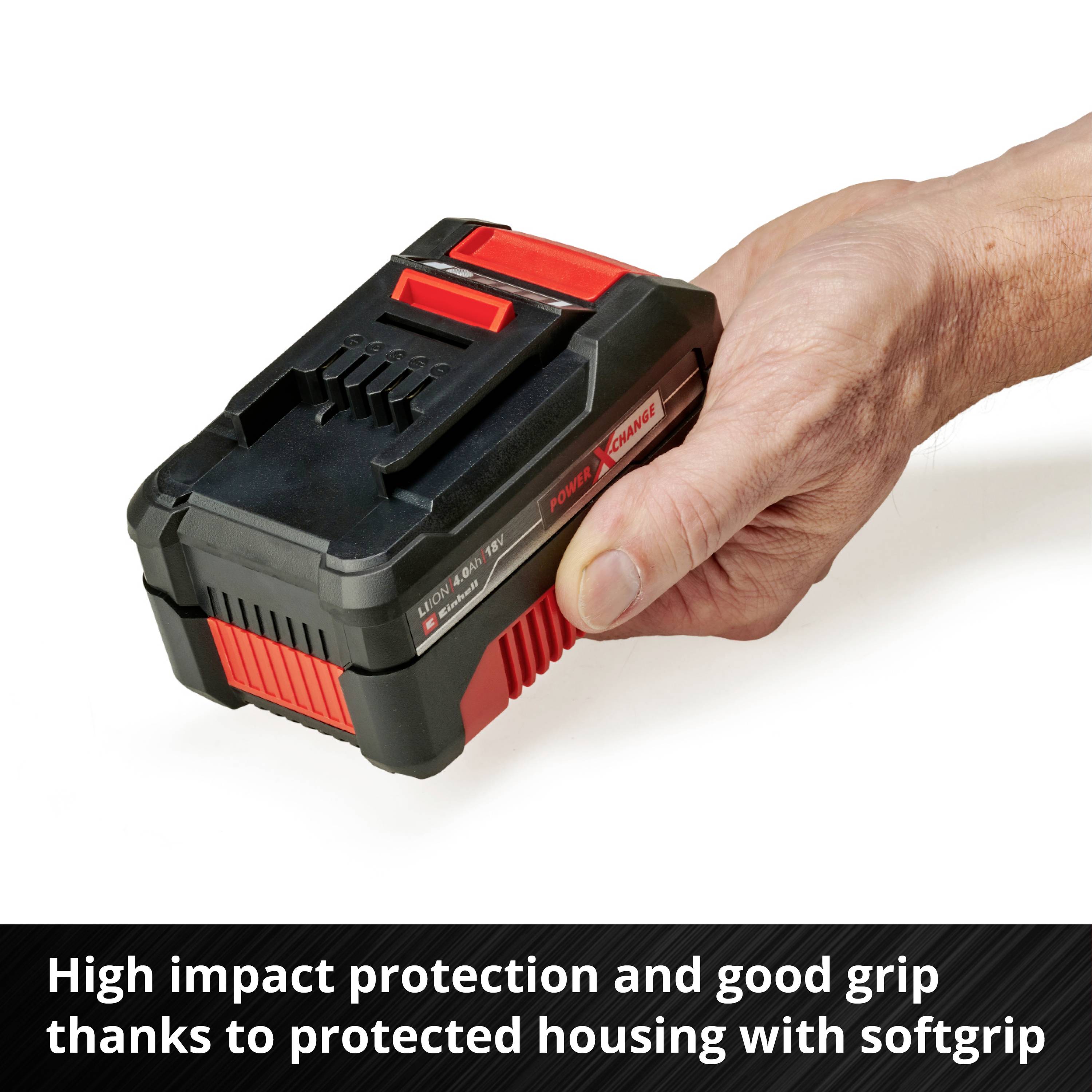 Une batterie rectangulaire avec un boîtier rouge et noir est tenue dans une main. La batterie offre une protection contre les chocs et une prise en main souple.