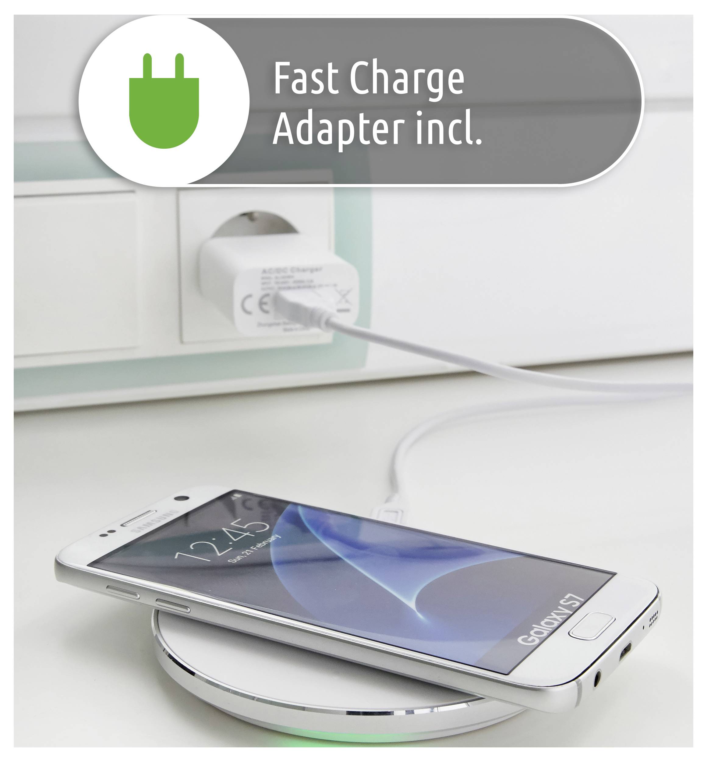 Un smartphone est en charge sans fil sur une base. Un adaptateur secteur est branché dans une prise murale. Une étiquette indique « Adaptateur de charge rapide inclus ».