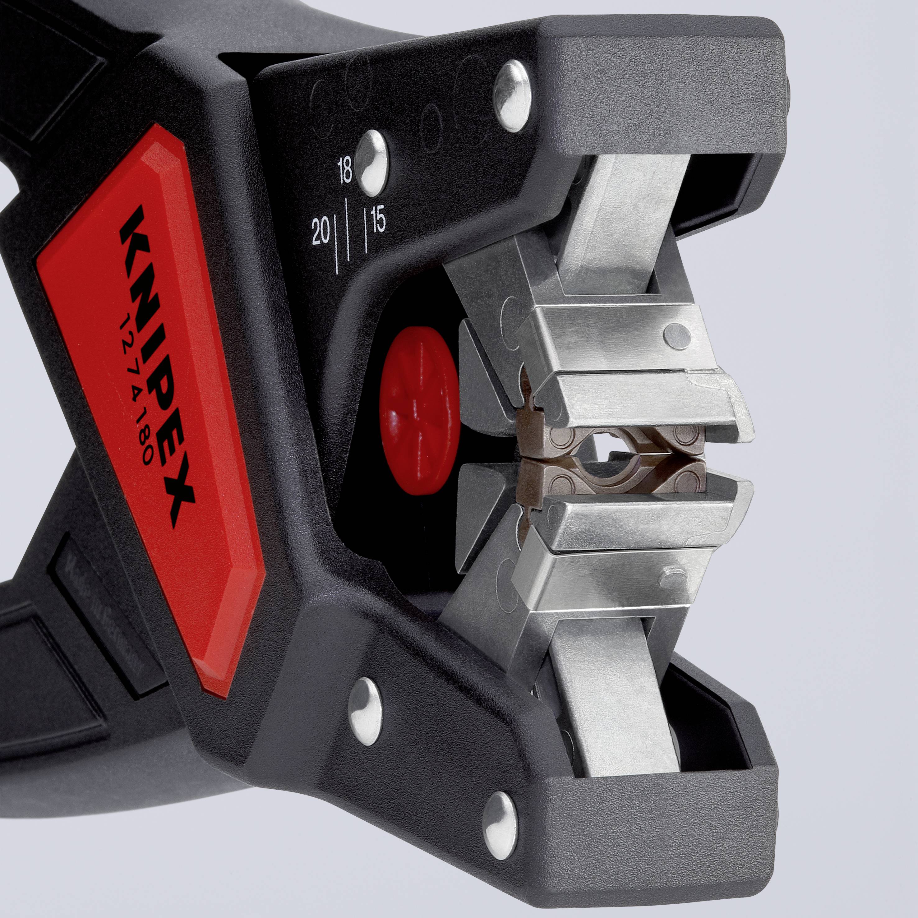 Pince à dénuder de marque 'KNIPEX' avec une poignée rouge et noire. Adaptée pour dénuder des câbles de différentes tailles.