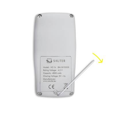 Dos d'un appareil avec l'étiquette : « SAUTER, Modèle : HO 1K, Tension : 4,2V, Capacité : 4800 mAh ». Une flèche jaune pointe vers une antenne.