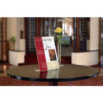 Une brochure de l'hôtel présentée sur une table met en avant les offres et services du Savoy City Hotel. Une rose jaune est disposée à côté comme élément de décoration. L'intérieur de l'hôtel est visible en arrière-plan.