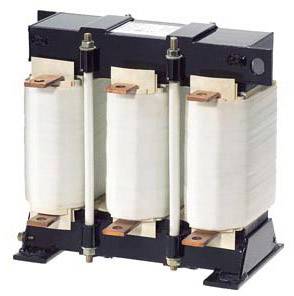 Un transformateur triphasé avec trois bobines verticales montées dans un boîtier métallique.