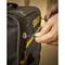 Une main tire sur la fermeture éclair d'un sac à outils noir. L'inscription jaune indique 'STANLEY'.