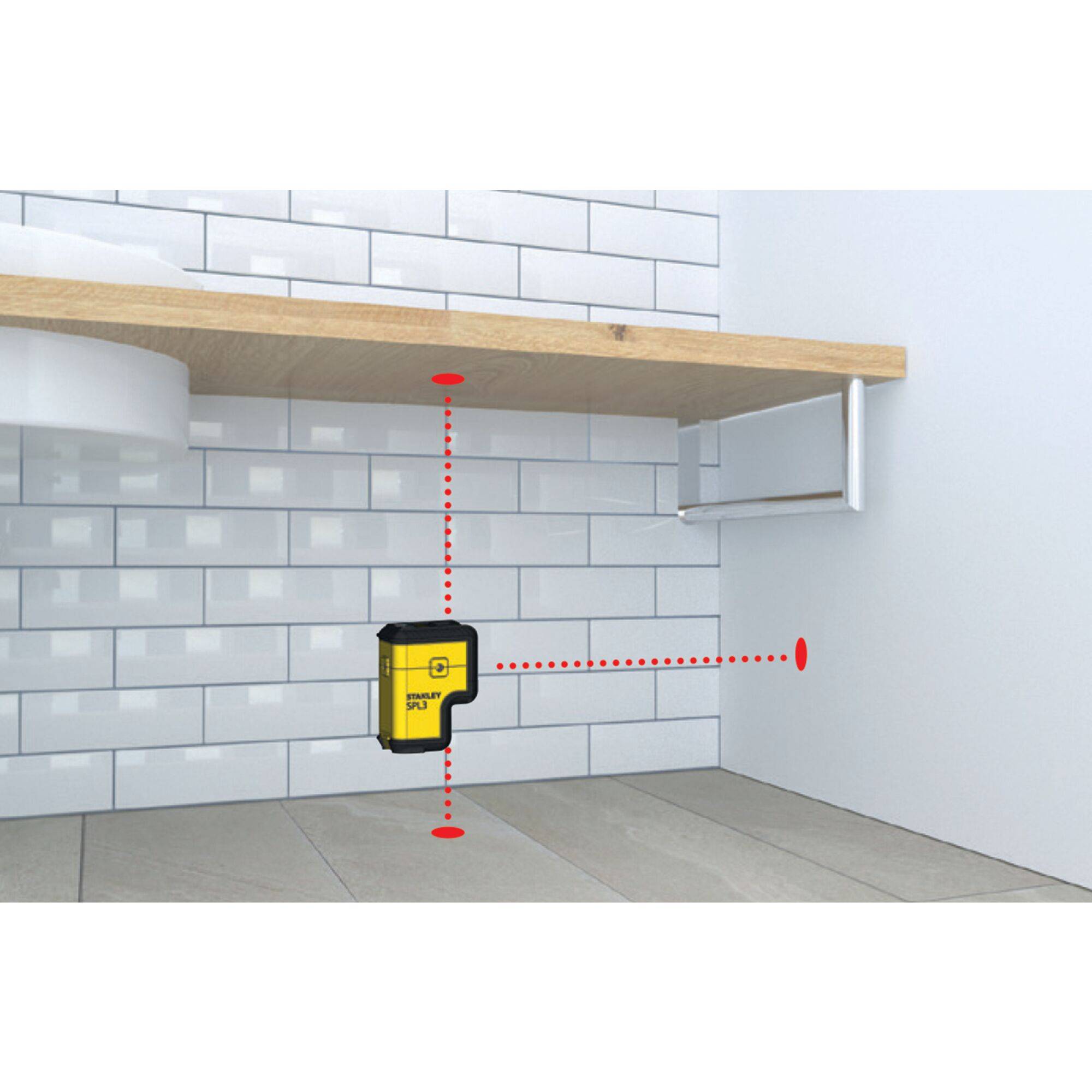 Un appareil de nivellement laser projette des lignes rouges sur les murs d'une salle de bain. Il indique les niveaux horizontaux et verticaux.