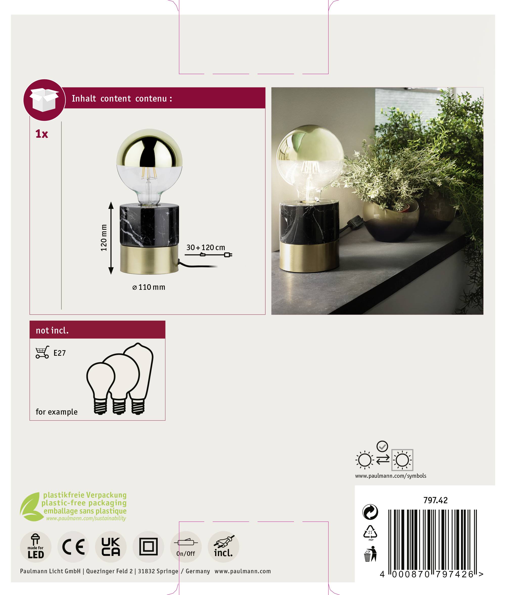 Une lampe de table dans un carton, contenant une ampoule. Illustrée avec des plantes sur une table. Comprend des informations sur les pièces incluses et les dimensions.