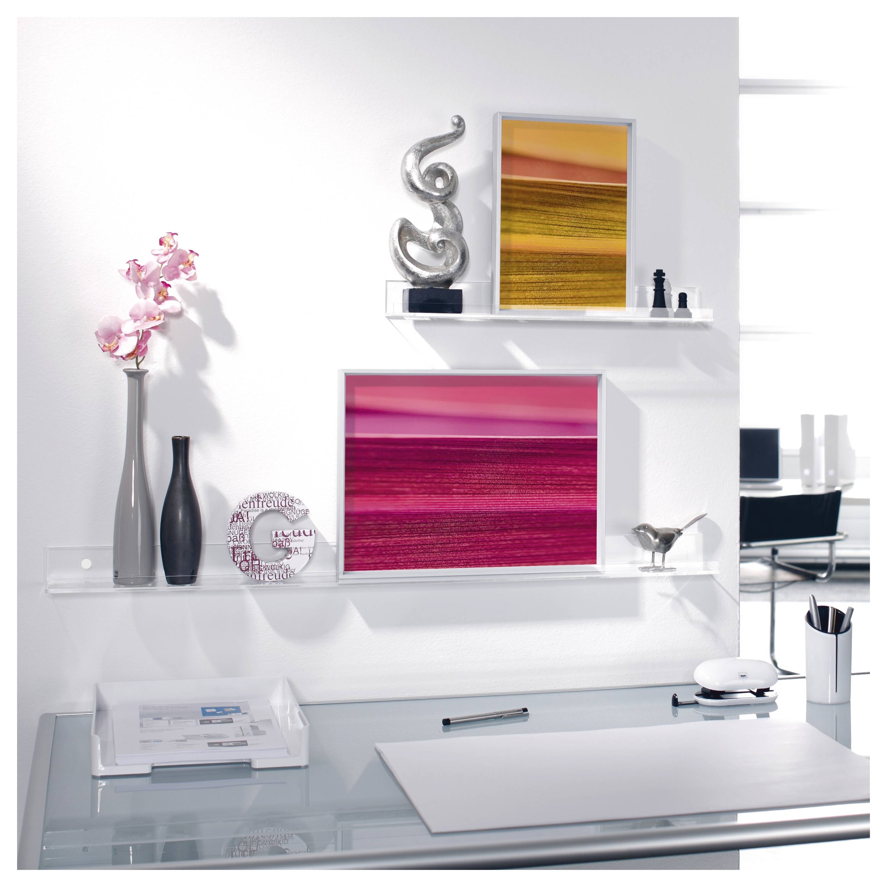 Mur de bureau blanc moderne avec art abstrait encadré, vases décoratifs et un bureau en verre avec des papiers et du matériel de bureau