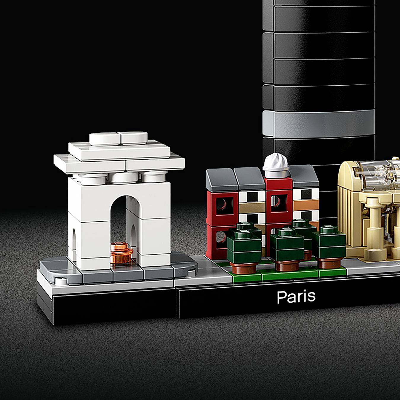 Maquette LEGO de Paris montrant des répliques miniatures de monuments emblématiques tels que l'Arc de Triomphe et un gratte-ciel, sur un fond noir.