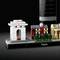 Maquette LEGO de Paris montrant des répliques miniatures de monuments emblématiques tels que l'Arc de Triomphe et un gratte-ciel, sur un fond noir.
