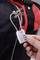 Une main referme un cadenas à code argenté sur un sac de sport au design rouge et noir, garantissant sa sécurité.