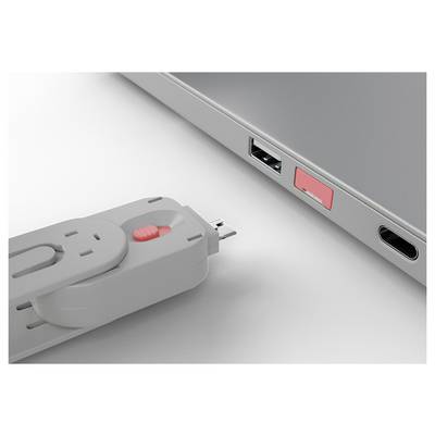 Une clé USB étant insérée dans le port USB d'un ordinateur portable à côté d'un autre port occupé.