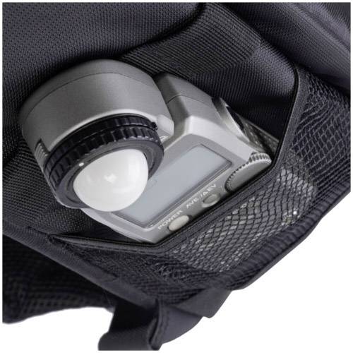 Un posemètre dans un étui de filet. L'appareil présente un écran et un élément circulaire pour mesurer la lumière.