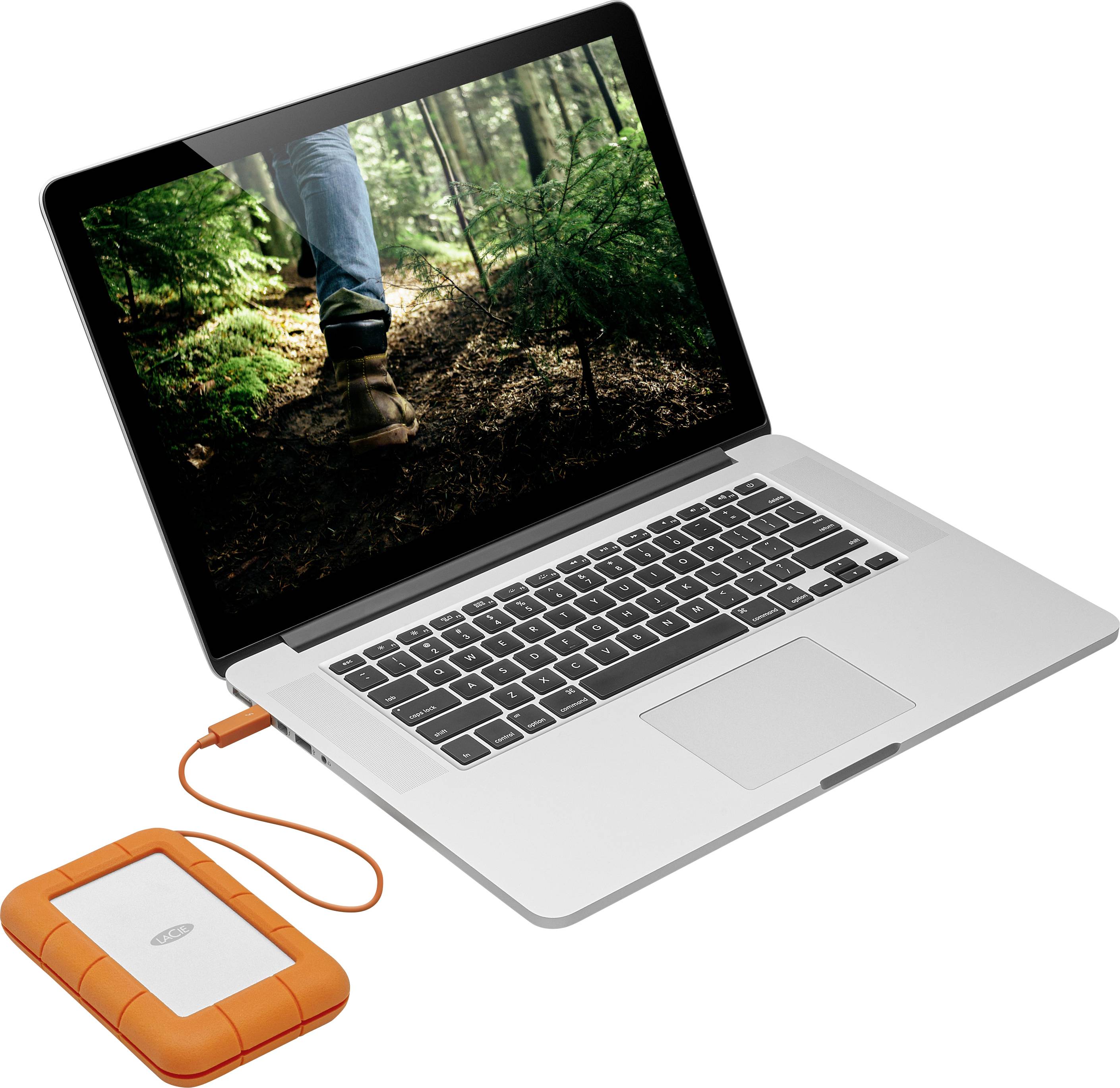 Un ordinateur portable ouvert affiche une photo d'un chemin forestier sur son écran. Une disque dur externe blindée orange y est connectée.