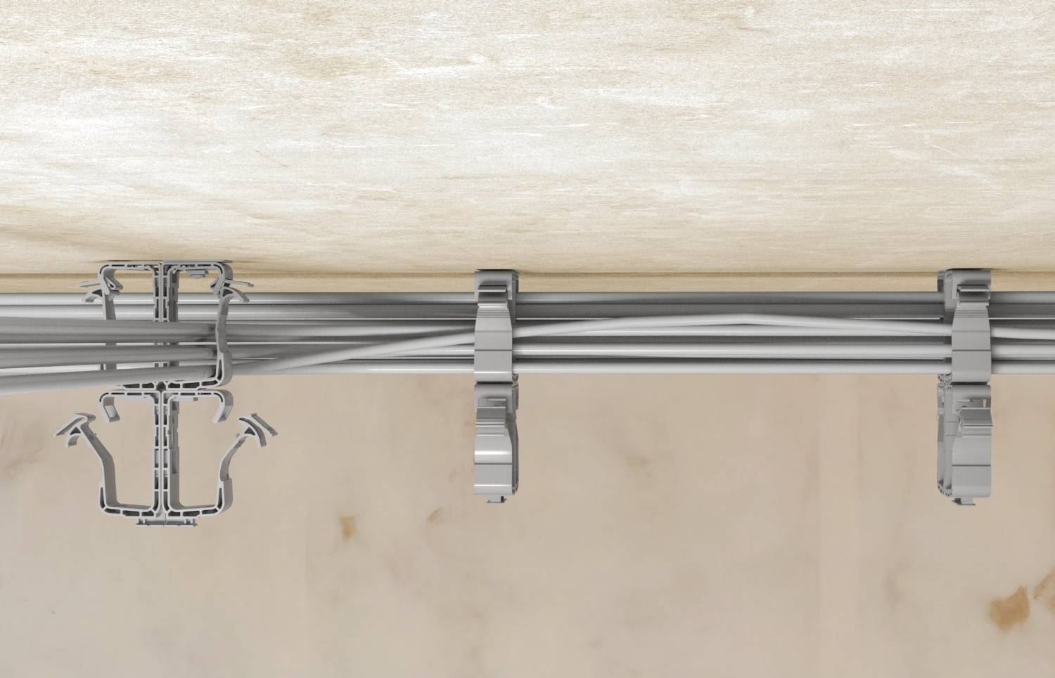Gros plan d'une goutte de câbles longeant un mur et un plafond, fixée par des colliers métalliques et un support de suspension.