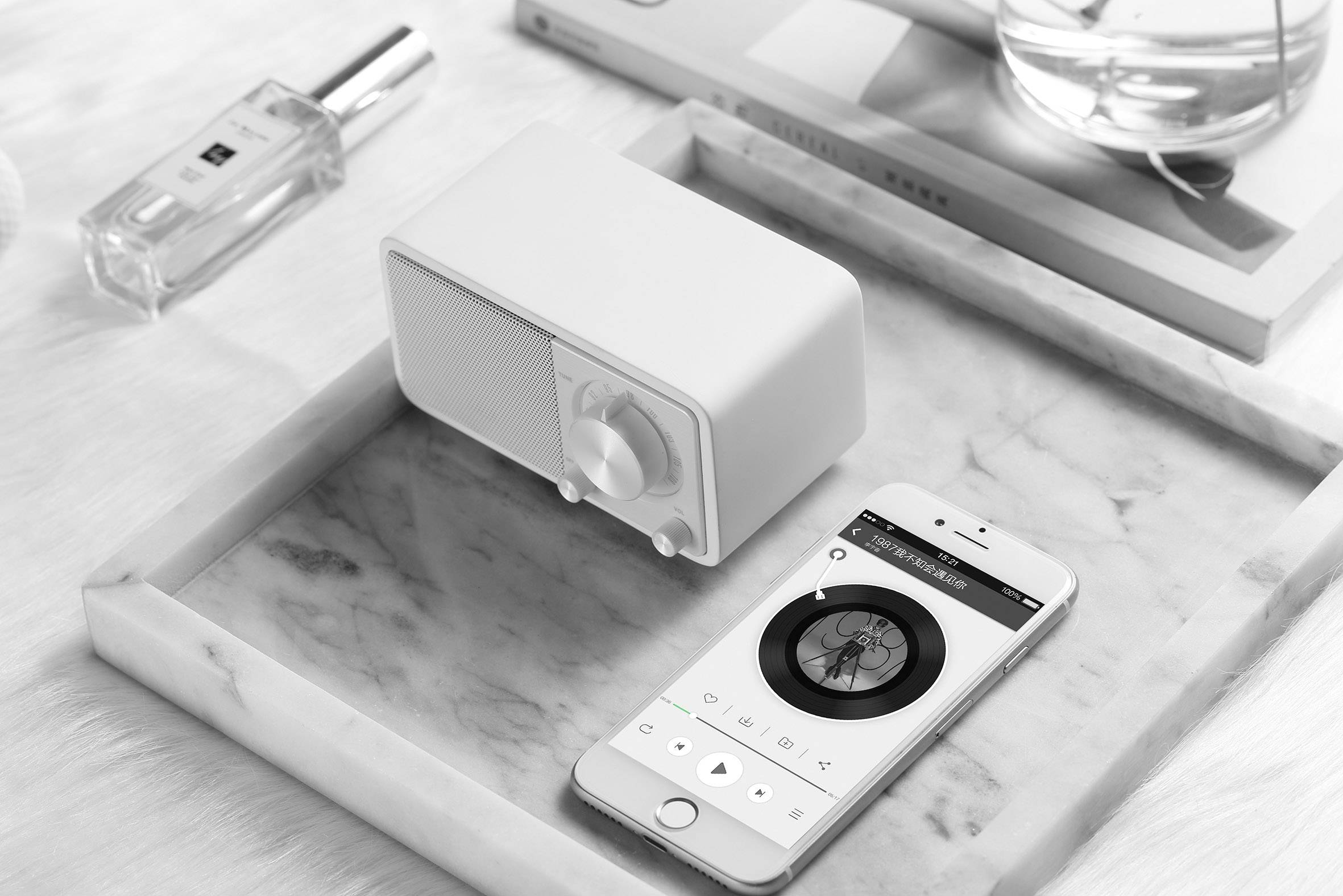 Un smartphone est posé sur une table et affiche une application de musique. À côté se trouve un petit haut-parleur. Représentation parfaite de la technologie moderne.