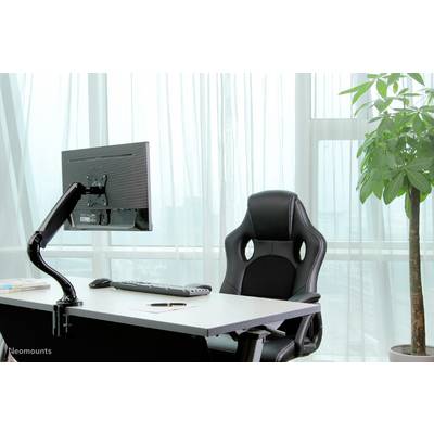 Un espace de bureau moderne avec un bureau, un écran, un clavier et une chaise ergonomique. Un grand plant est placé à droite près de la fenêtre.