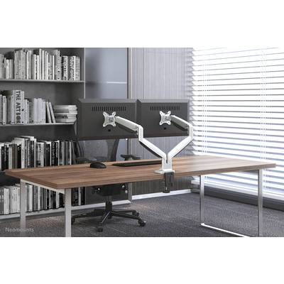 Un bureau moderne avec deux écrans sur supports, une chaise de bureau noire et une bibliothèque en arrière-plan.