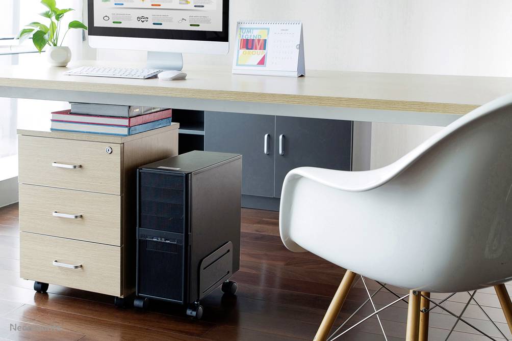 Environnement de bureau moderne avec un bureau, un ordinateur, une pile de livres et un calendrier de bureau. Un chaise blanche est au premier plan.
