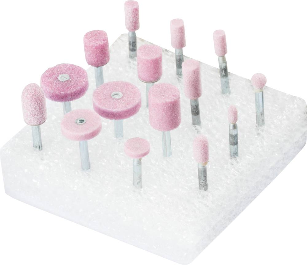 Divers outils de polissage roses avec des embouts métalliques sont disposés sur un bloc de mousse blanc.