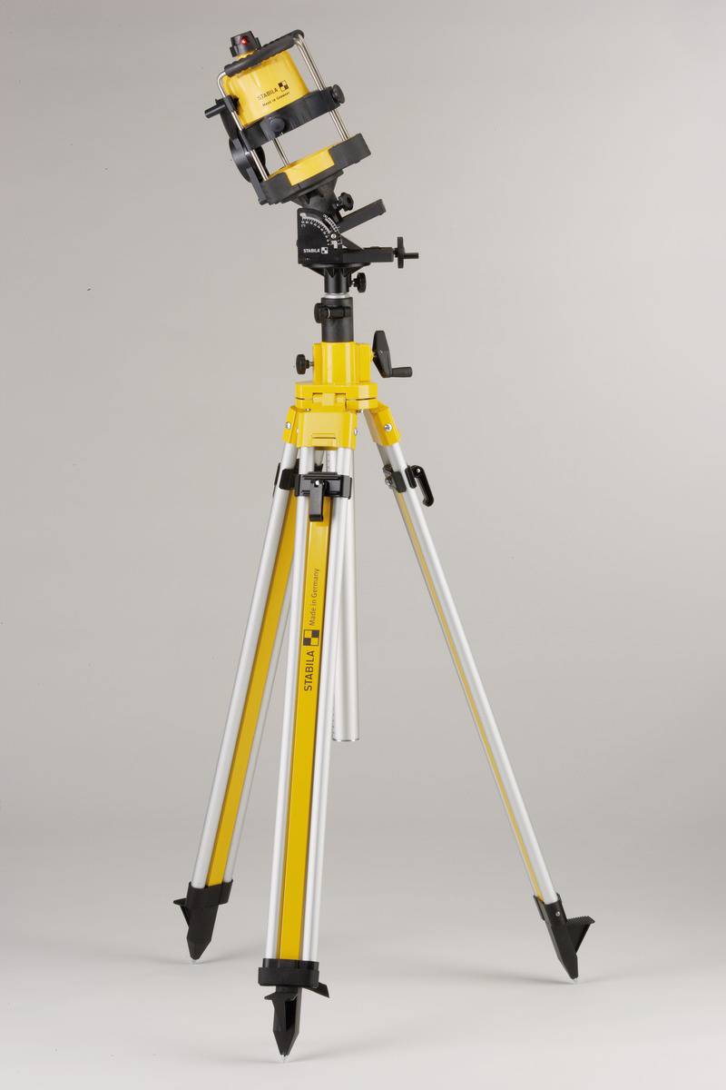 Un théodolite jaune sur un trépied télescopique pour mesurer avec précision les angles et les distances.