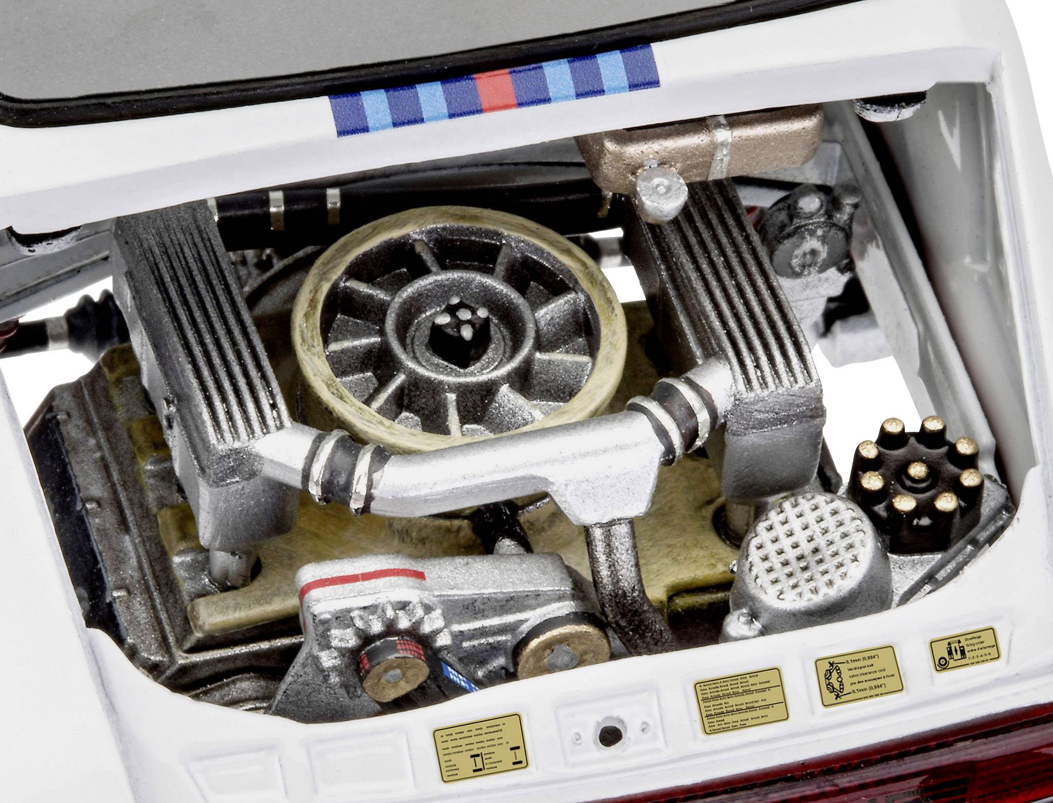 Vue d'une reproduction détaillée de moteur dans un modèle de véhicule. Pièces du moteur visibles et autocollants avec petits caractères.