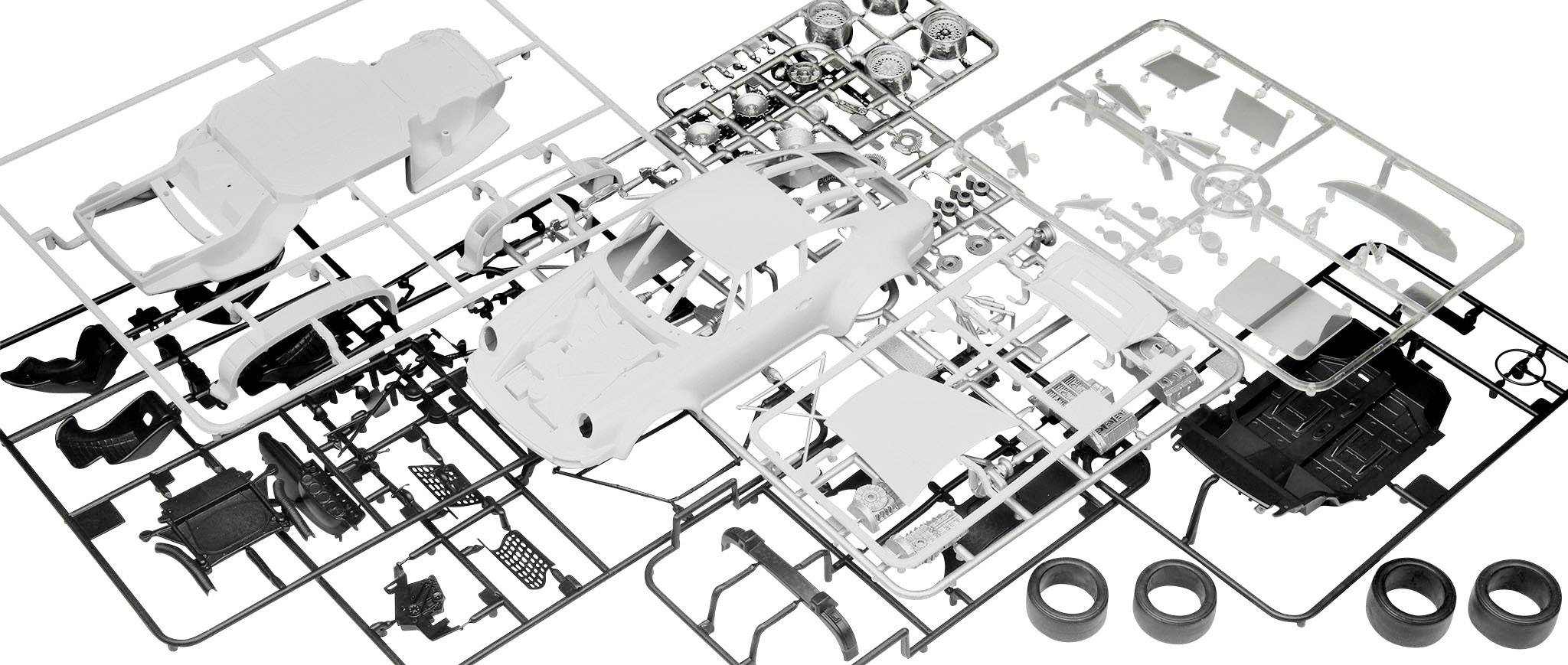 Pièces d'un kit de modélisme automobile, disposées en désordre sur une table. Différentes parties de voiture telles que la carrosserie, les pneus et le moteur sont visibles.
