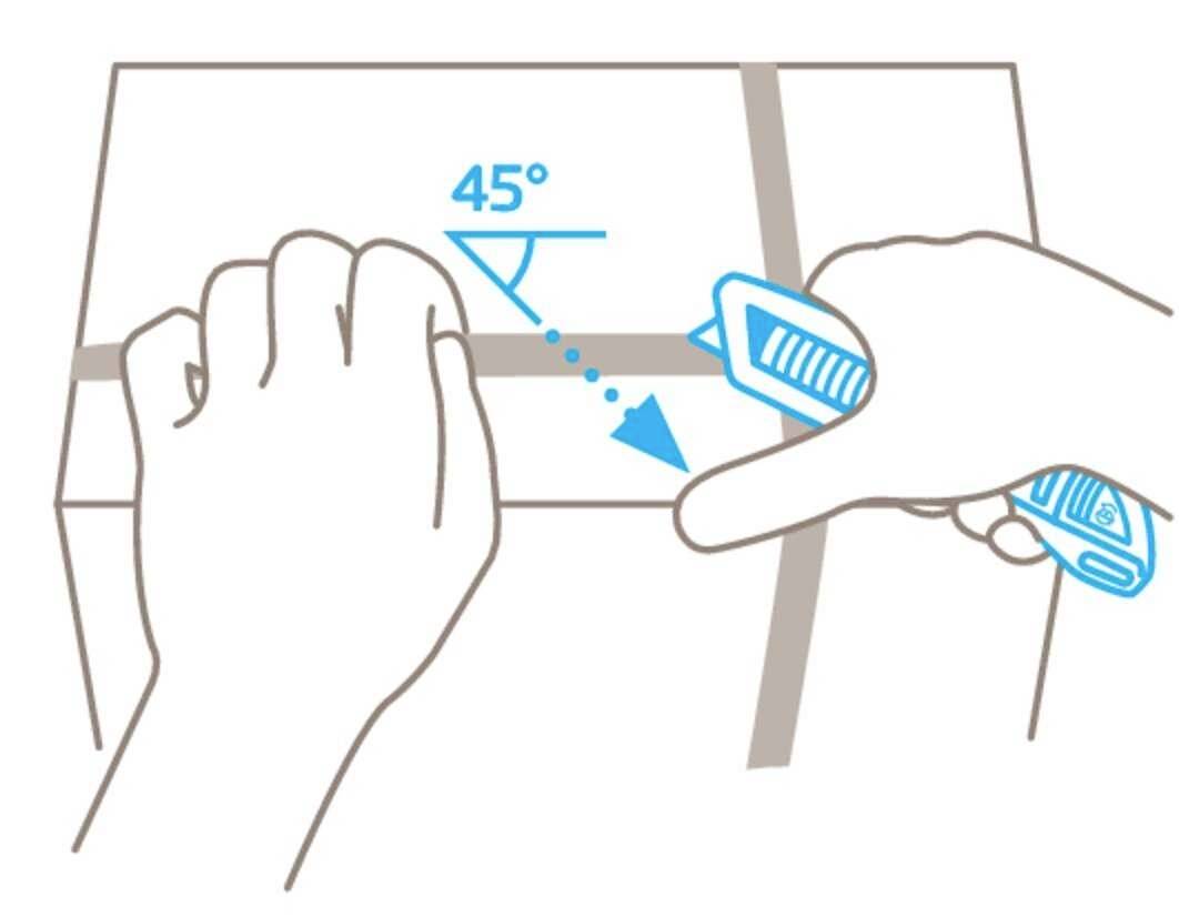 Une main coupe un ruban d'emballage avec un cutter selon un angle de 45 degrés.